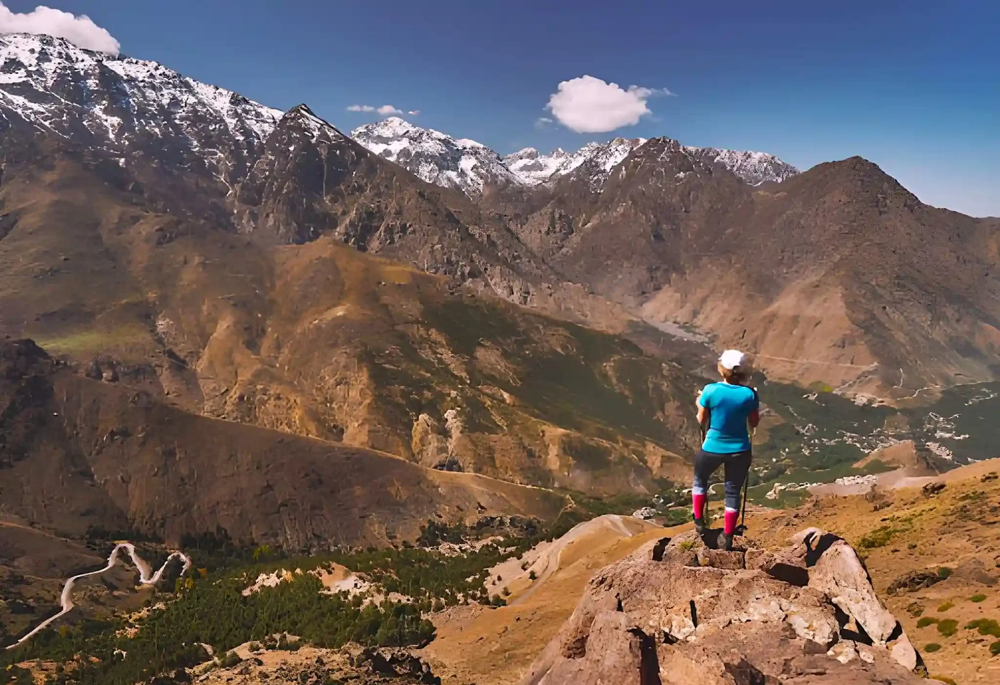 Gebirgsreise in Marokko – Wanderer im Atlasgebirge mit Blick auf schneebedeckte Gipfel